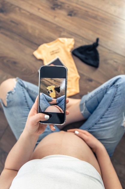 Schwangere Frau, die ein Ultraschallbild der Draufsicht des Babys fotografiert