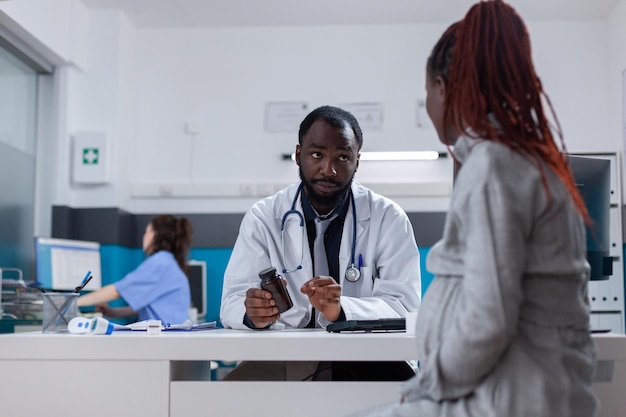 Schwangere Frau, die eine Flasche Pillen von einem Spezialisten erhält, um Krankheiten zu heilen. Arzt im Gesundheitswesen, der Patienten mit Schwangerschaft in der Arztpraxis verschreibungspflichtige Behandlung und Medikamente gibt