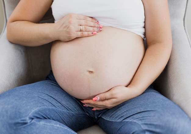 Schwangere Frau, die ihren Bauch hält