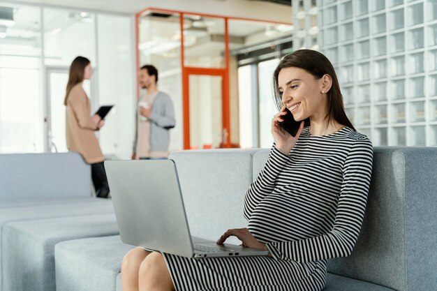 Schwangere Frau, die im Büro arbeitet