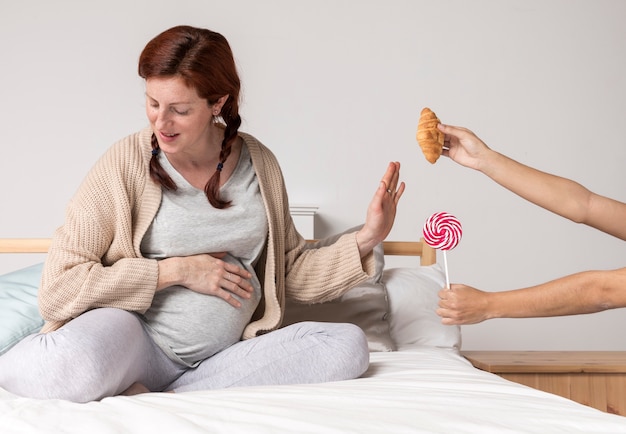 Schwangere Frau, die Snacks ablehnt