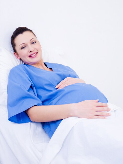 Schwangere Frau, die vor der Geburt im Entbindungsheim liegt