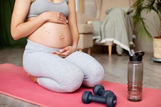 Kostenloses Foto schwangere frau, die zu hause trainiert