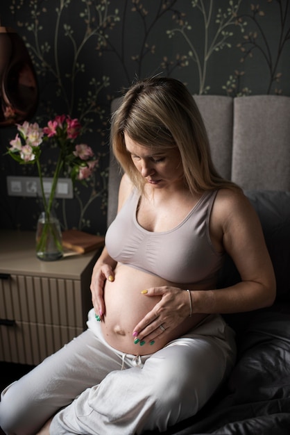 Kostenloses Foto schwangere frau im innenbereich mit mittlerer aufnahme
