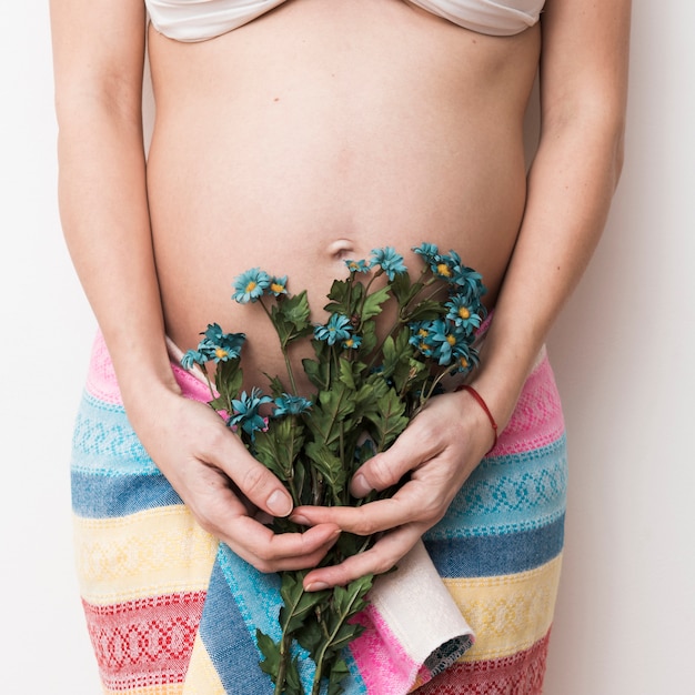 Schwangere Frau mit Blumenstrauß