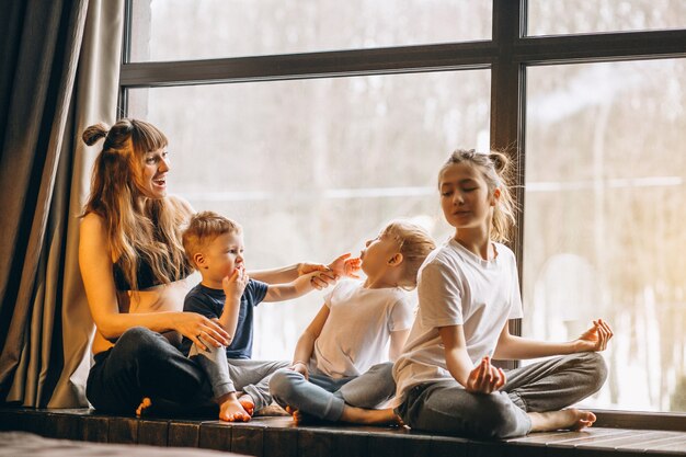 Schwangere Frau mit Kindern am Fenster sitzen