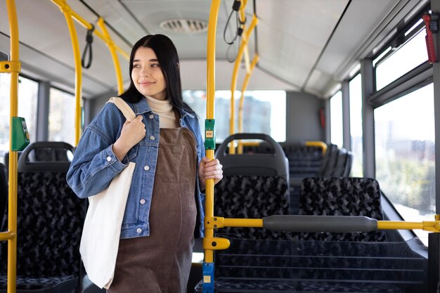Schwangere Frau mit mittlerer Aufnahme, die mit dem Bus reist
