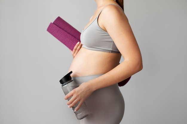 Schwangere frau mit sportgeräten