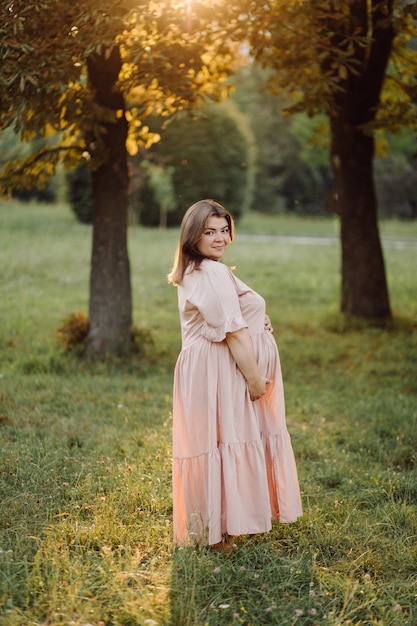 Schwangere Frau posiert im Park