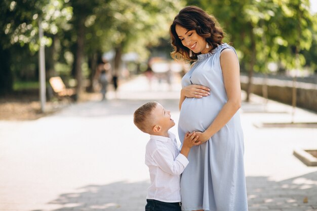 Schwangere Frau und ihr kleiner Sohn im Park