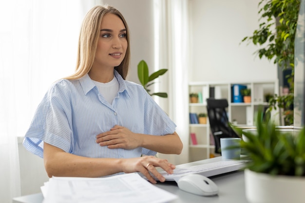 Schwangere Geschäftsfrau, die im Büro arbeitet