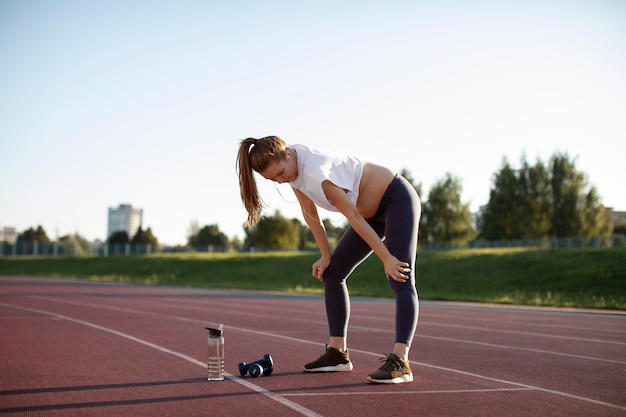 Schwangere macht eine Pause vom Sport im Freien