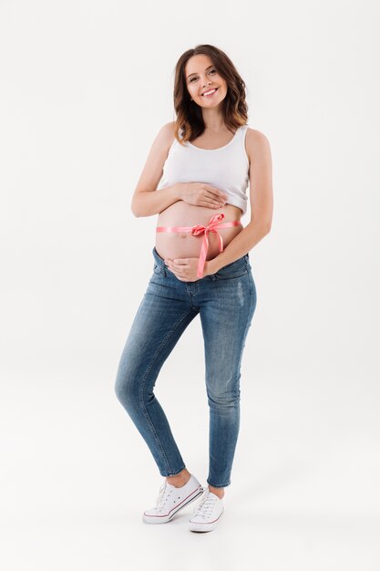 Schwangere stehende isoliert mit einem Bogen auf dem Bauch