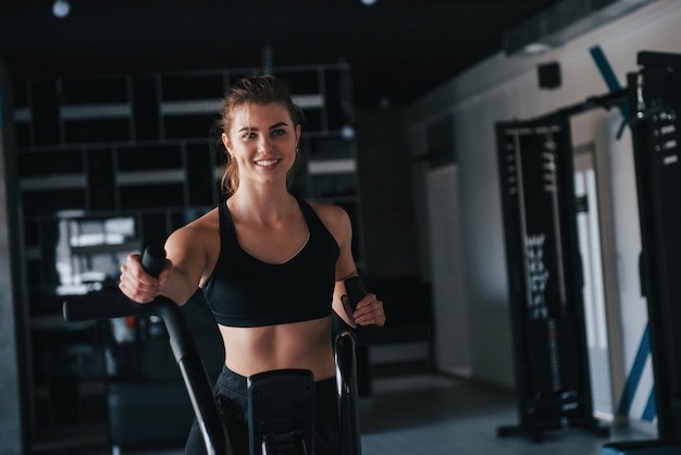 Schwarz gefärbte Ausrüstung. wunderschöne blonde Frau im Fitnessstudio zu ihrer Wochenendzeit