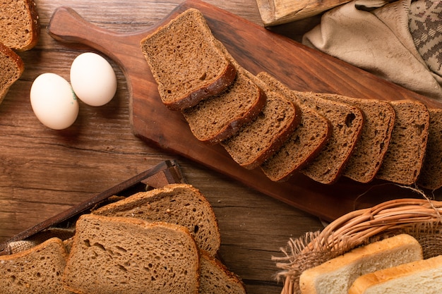 Schwarzbrotscheibe auf Küchenbrett mit Eiern