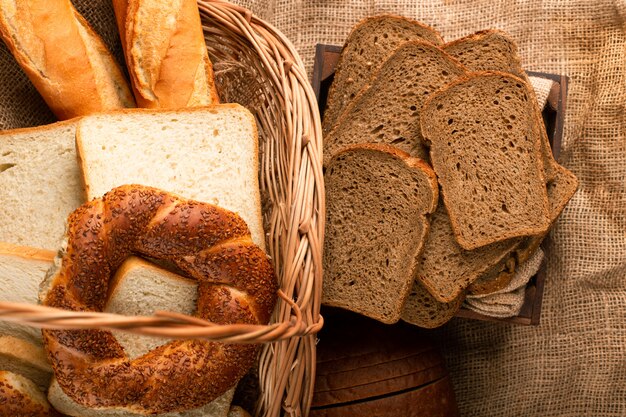 Schwarzbrotscheiben in Schachtel und Bagels mit Baguette im Korb