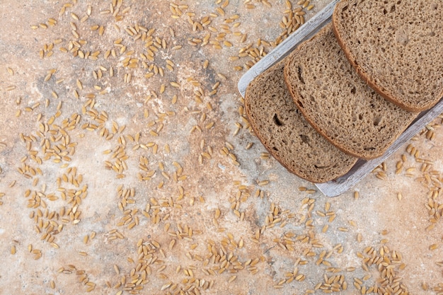 Schwarzbrotscheiben mit Gerstenkörnern auf Marmoroberfläche