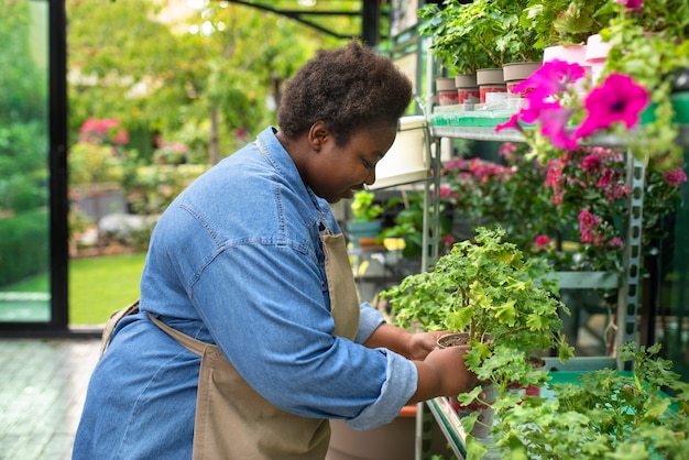 Kostenloses Foto schwarze frau, die eine seitenansicht des blumengeschäfts betreibt