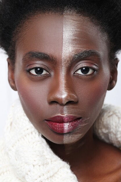 Schwarze Frau mit halbem Gesicht auf Make-up, Schönheitskonzept