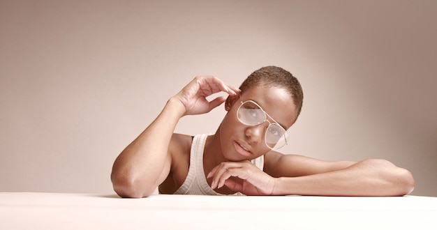 Schwarze Frau mit kurzem Haarschnitt im Studio-Shooting in Nahaufnahme mit Brille Kobra