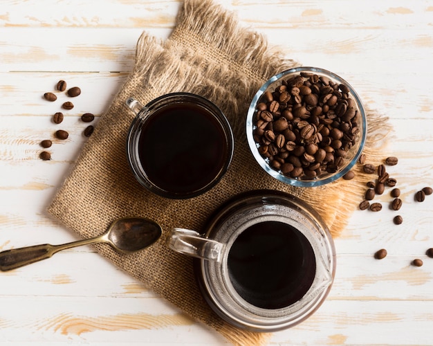 Schwarze Kaffeeanordnung der Draufsicht auf Stoff