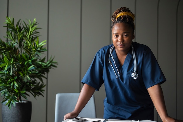 Kostenloses Foto schwarze krankenschwester der vorderansicht, die stethoskop trägt