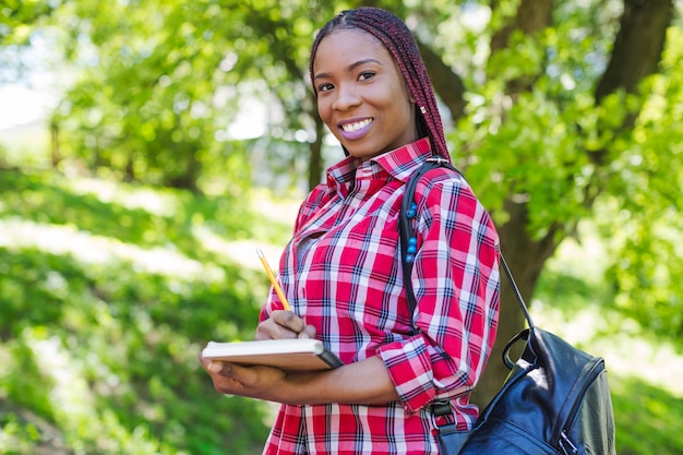 Schwarze Mädchen posiert mit Notizblöcken
