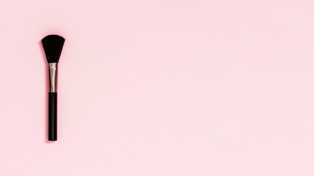 Schwarze Make-upbürste auf rosa Hintergrund