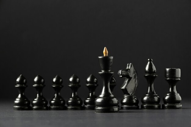 Schwarze Schachfiguren auf schwarzem Hintergrund