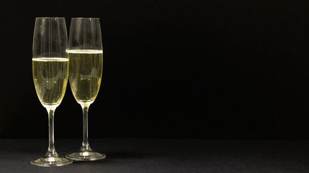 Schwarze Szene mit zwei Gläsern Champagner.