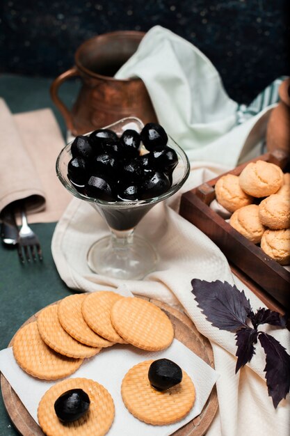 Schwarze traditionelle Walnusskonfektion in einem Glas mit Butterkeksen herum