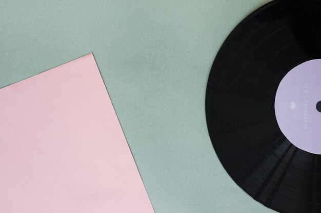 Schwarze Vinylaufzeichnung mit Papier auf Tabelle