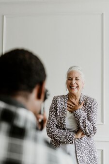 Schwarzer fotograf, der ein foto von einer fröhlichen älteren frau macht