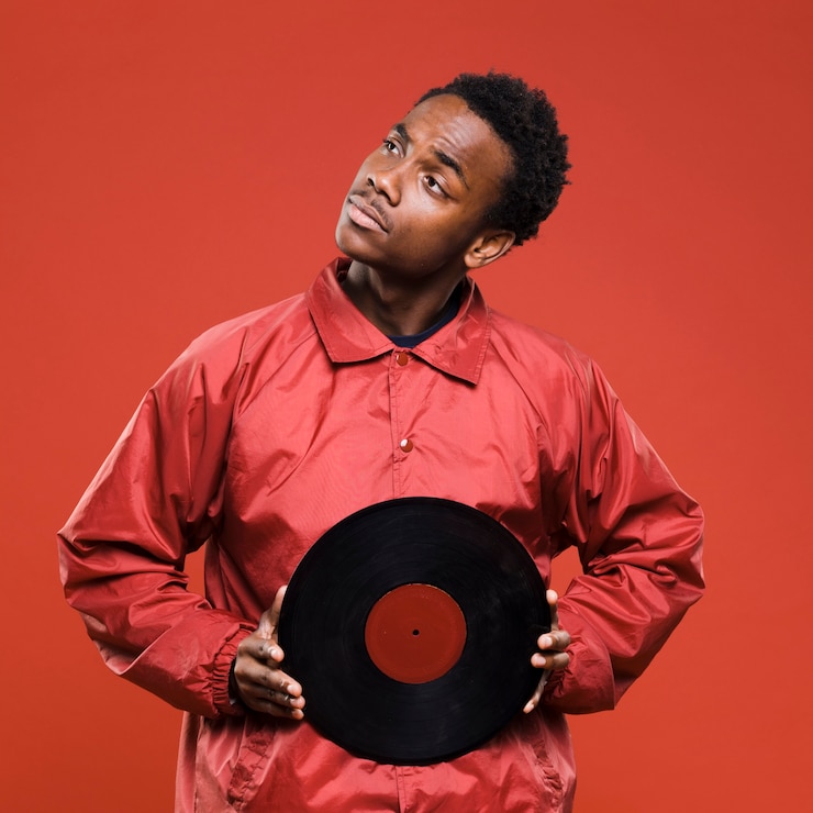Kostenlose Foto schwarzer junge, der mit vinyls aufwirft
