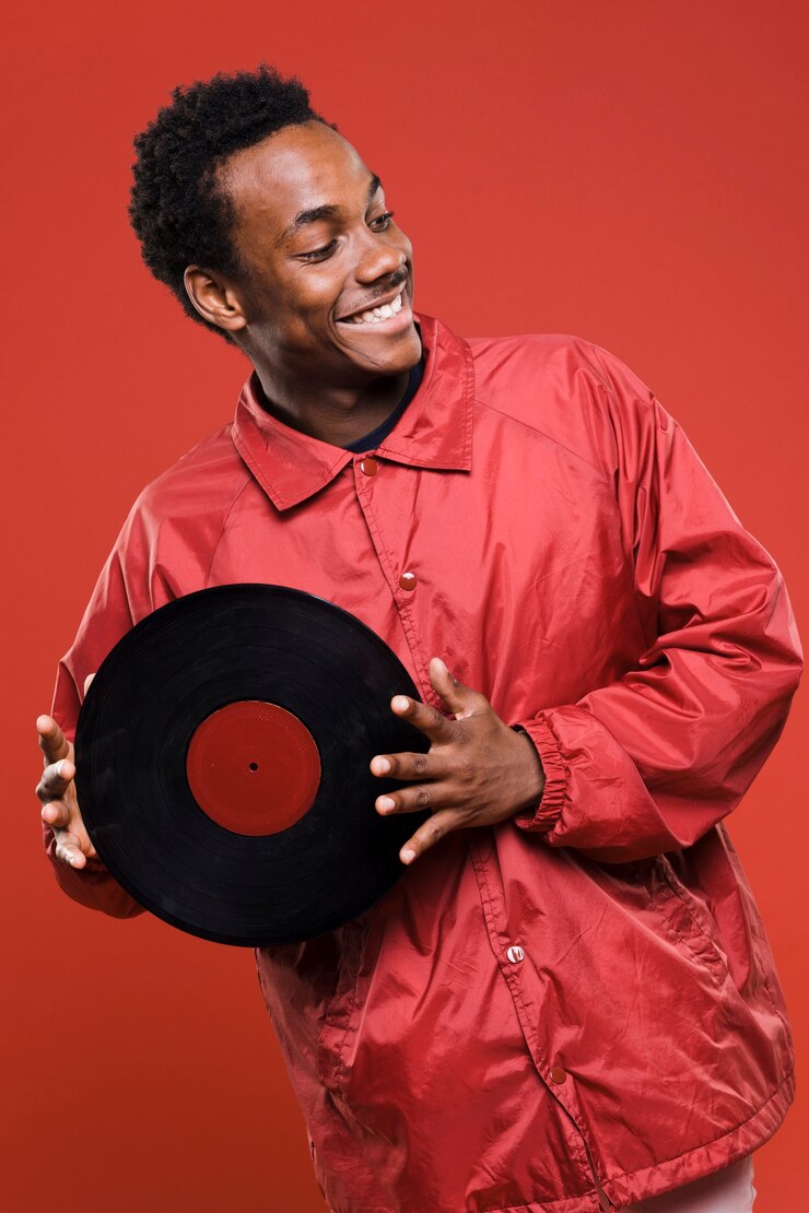 Kostenlose Foto schwarzer junge, der mit vinyls aufwirft