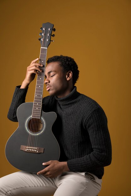 Schwarzer Junge spielt Gitarre