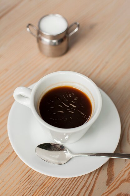 Schwarzer Kaffee mit Milch auf Schreibtisch am Caféshop