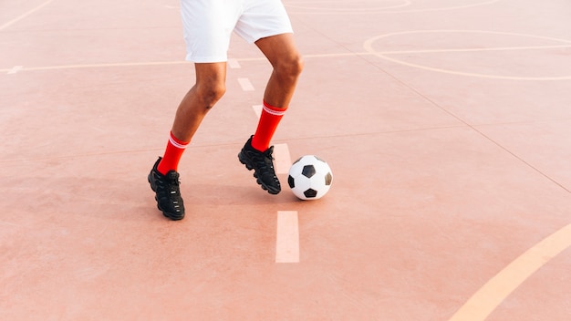 Kostenloses Foto schwarzer mann, der fußball am stadion spielt