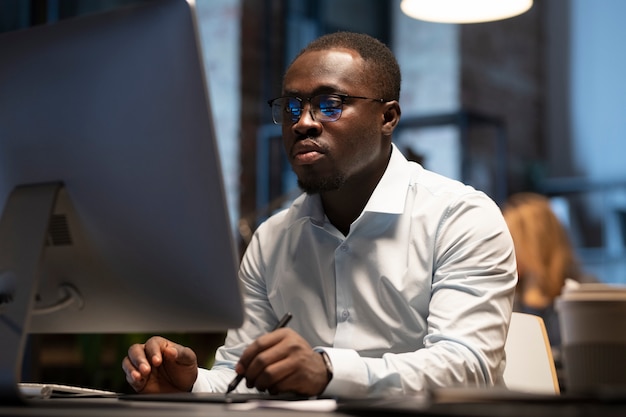 Schwarzer Mann, der mit einem Computer arbeitet