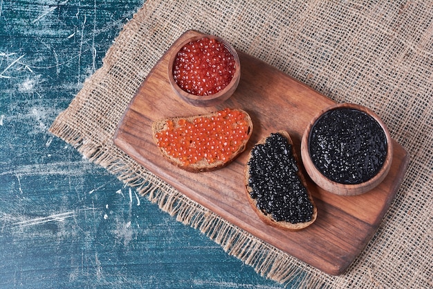 Schwarzer und roter kaviar auf brotscheibe.