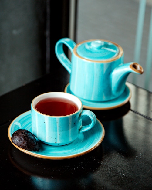 Schwarzes Plätzchen und Tasse schwarzen Tee