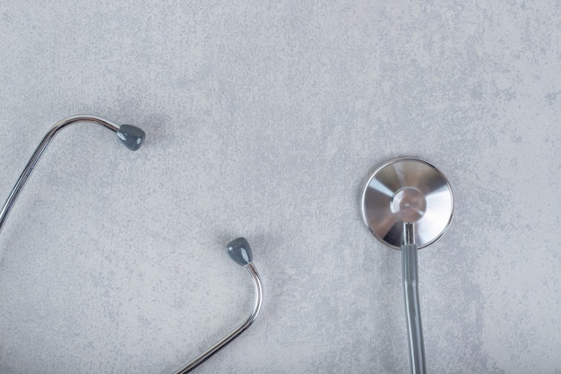 Schwarzes Stethoskop isoliert auf grauer Oberfläche