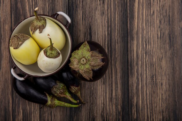 Schwarzweiss-Aubergine der Draufsicht kopieren Raum in einem Topf auf hölzernem Hintergrund