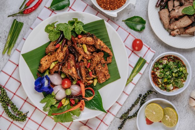 Schweinefleisch Nam Tok mit gebratenem Chili, Tomate, Limette, Gurke und frischem Pfeffer. Thai Essen.