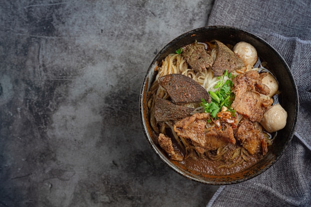 Schweinefleischbootnudeln, klassisches thailändisches Essen und beliebte Menüs sowie verzehrfertige Suppen. Es gibt auch ein Basilikum in der Schüssel.