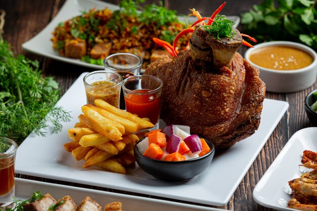 Schweinshaxe auf Deutsch mit Soßen auf dunklem Hintergrund