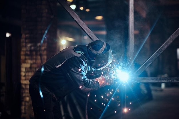 Schweißarbeiten mit Metallkonstruktion in einer geschäftigen Metallfabrik