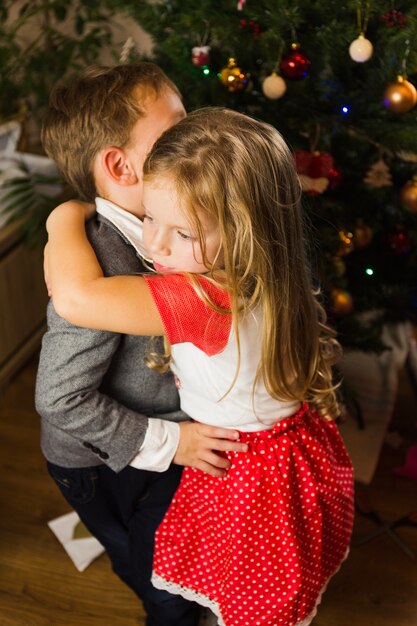 Schwester umarmt Bruder an Weihnachten