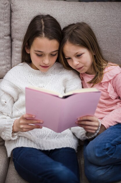 Kostenloses Foto schwestern, die zusammen buch lesen