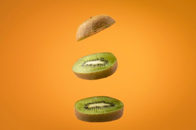 Schwimmende geschnittene Kiwi-Früchte mit klarem Hintergrund